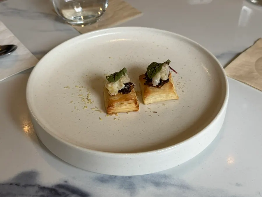 Appetizer pastry topped with pickled onion, shrimp, and scallop