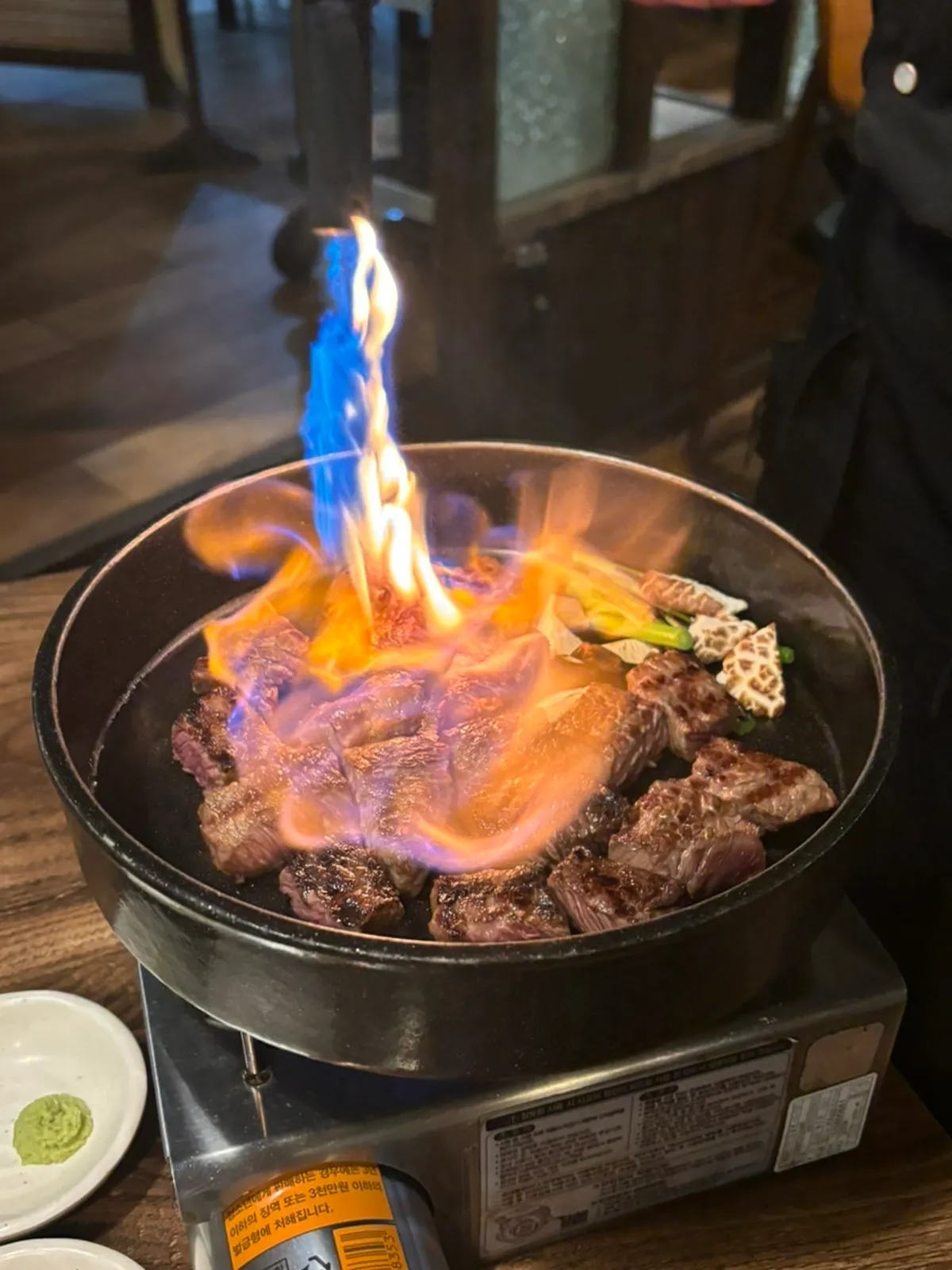 Fire show with flames rising after white wine is poured over the galbi