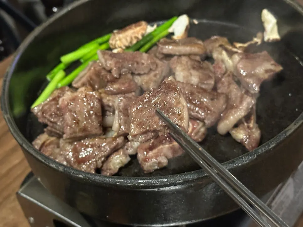 무쇠 팬에서 노릇하게 구워진 꽃갈비살