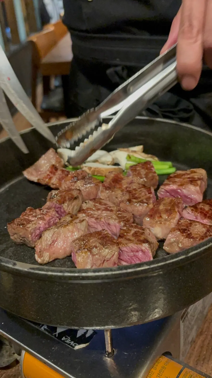 Staff member grilling the meat directly for the table