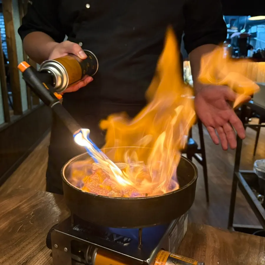 Flames rising from the tableside grill at Raviok