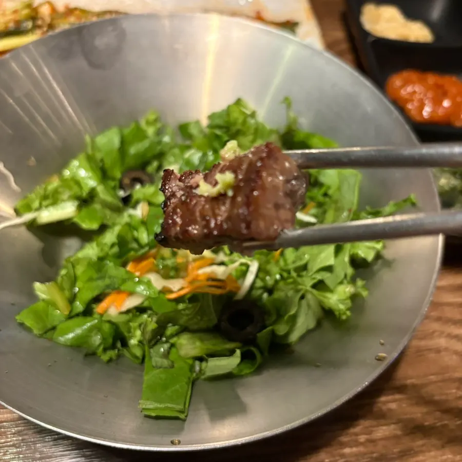 A piece of galbi picked up with chopsticks