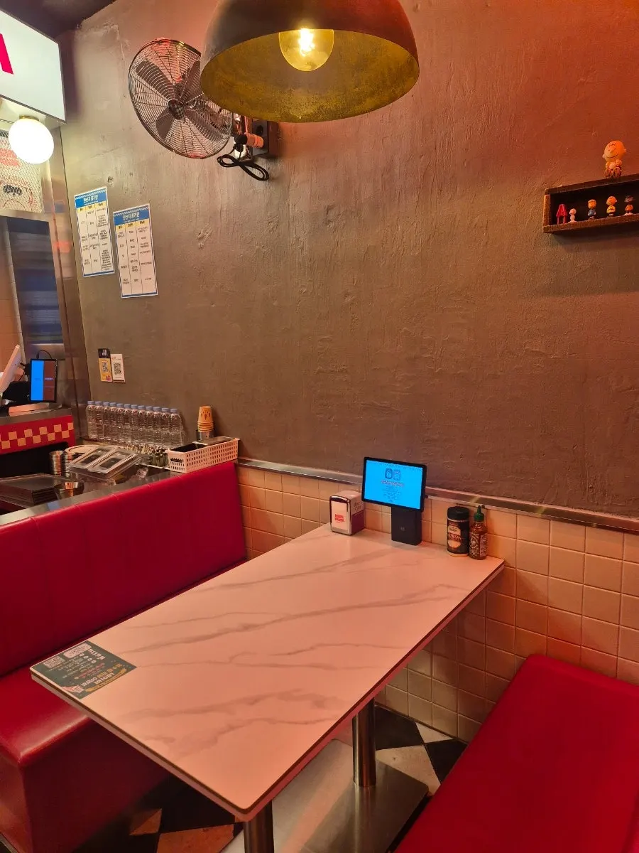 Interior of Raccoon Pizza Mapo Station branch with red-toned American-style decor