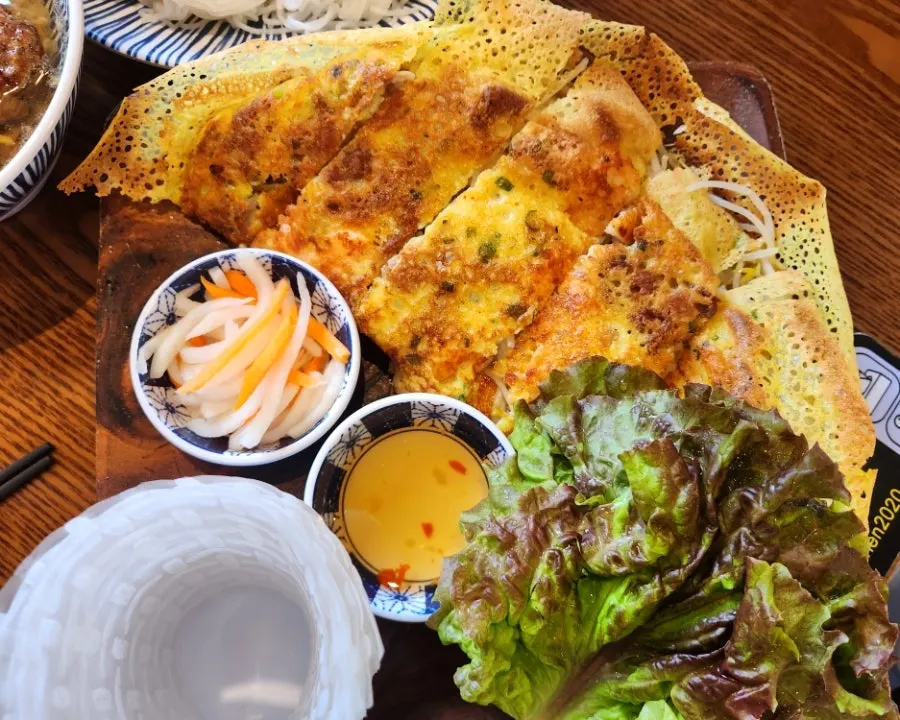 Banh xeo with side vegetables and rice paper