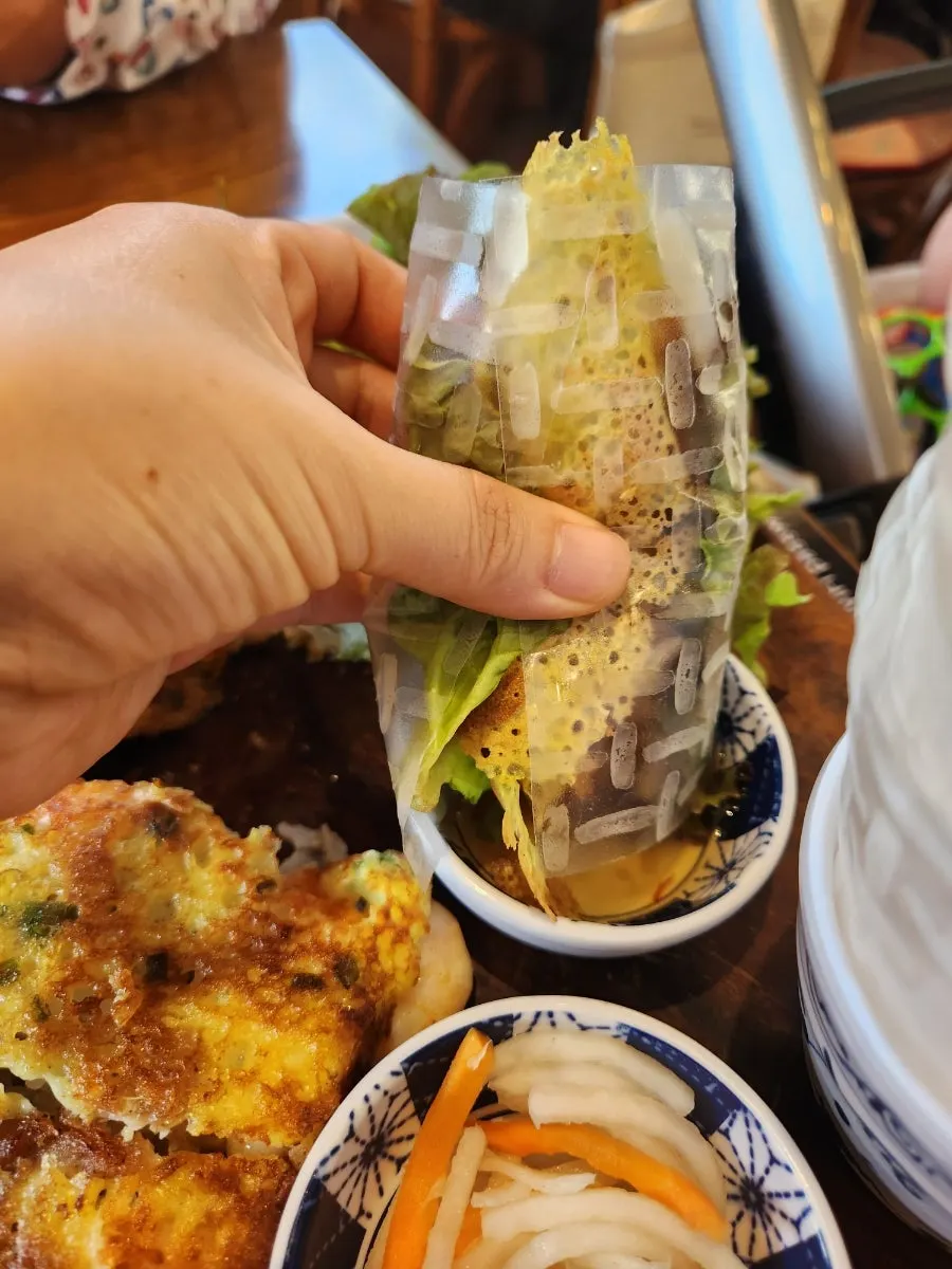 Banh xeo wrap dipped in nuoc mam sauce