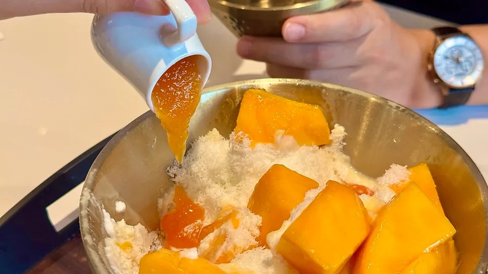The shaved ice hidden beneath the mango topping