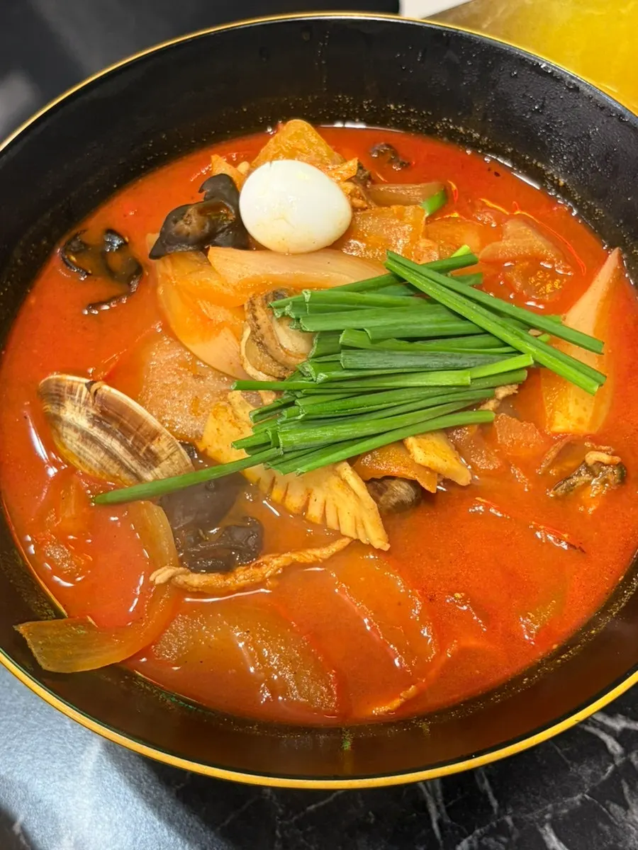 A piece of pork loin tangsuyuk dipped in sauce