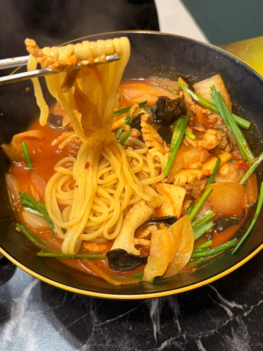 Noodles lifted up, showing the seafood and vegetables in the jjamppong