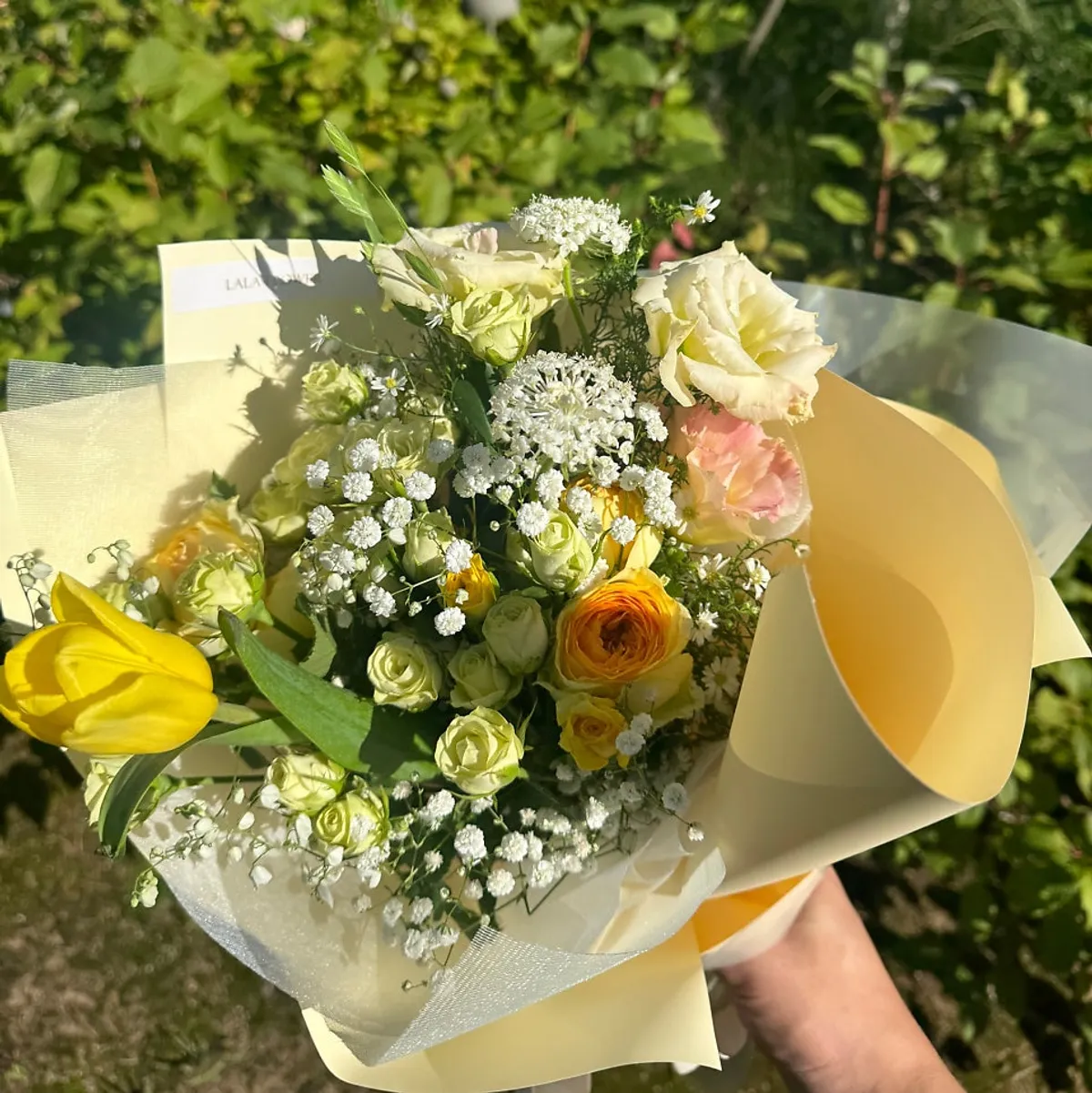 ช่อดอกไม้กุหลาบเหลือง ยิปโซ และทิวลิปสีเหลืองสดเป็นจุดเด่น