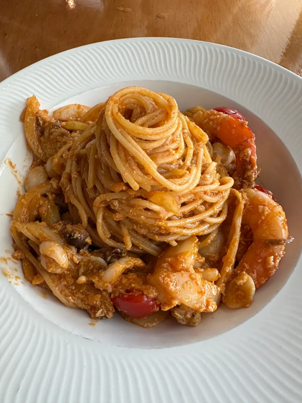 A plate of mie goreng with noodles coiled up