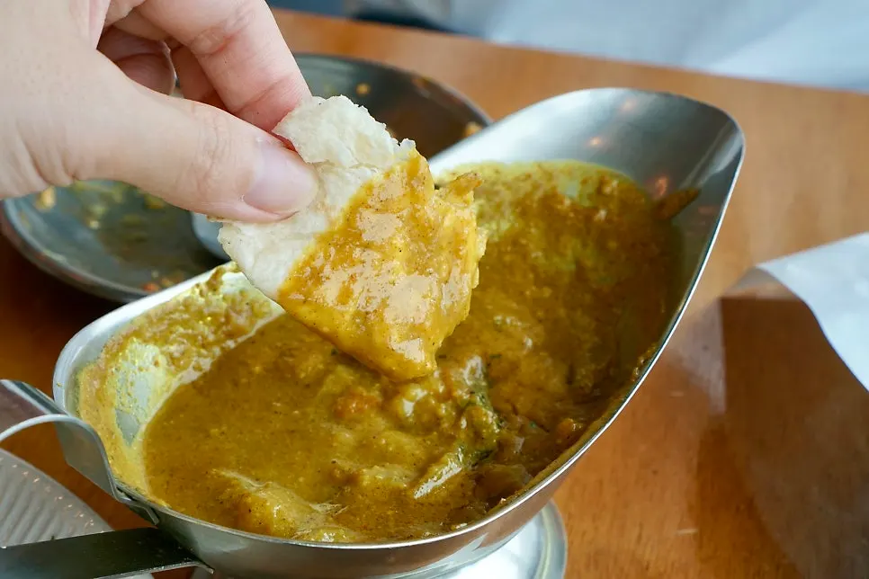 A piece of naan topped with curry