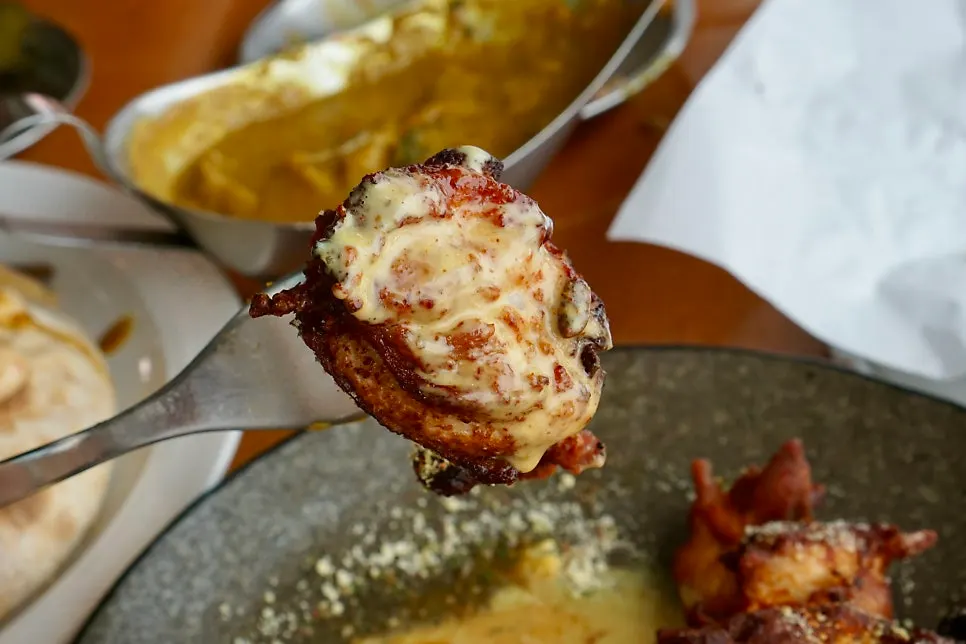 A piece of tandoori chicken coated in cream sauce