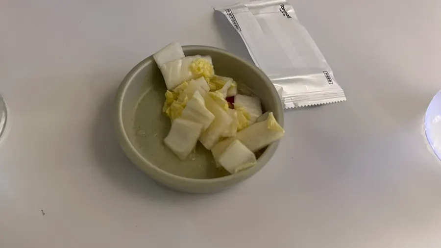 A plate of white kimchi served before the meal