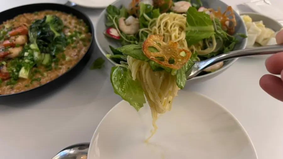 Noodles and greens twirled onto a fork