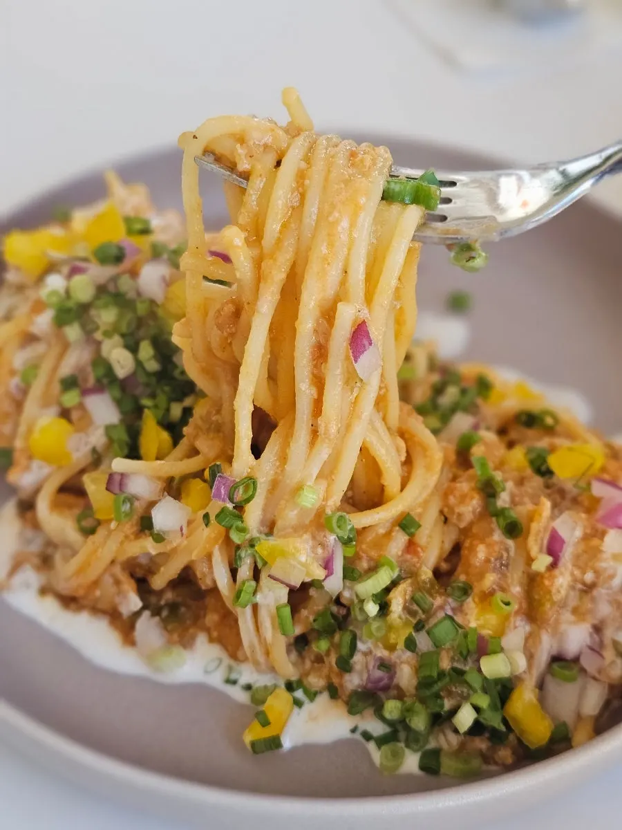 Close-up of ragu pasta noodles mixed with sauce