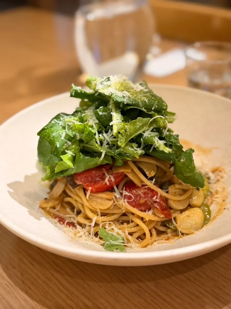 A plate of anchovy oil pasta topped with rucola