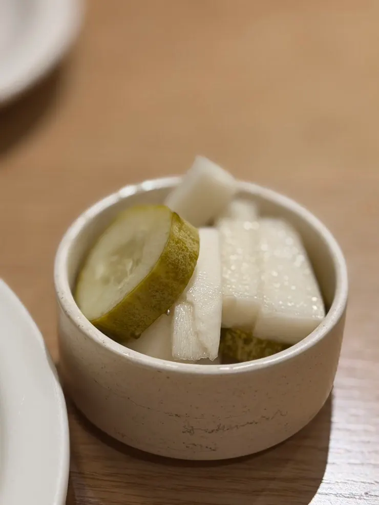 A small plate of pickles served with the pasta