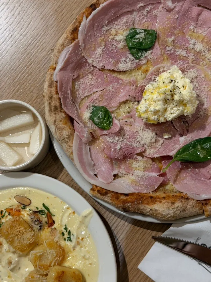 A slice of pizza topped with cotto ham and ricotta cheese