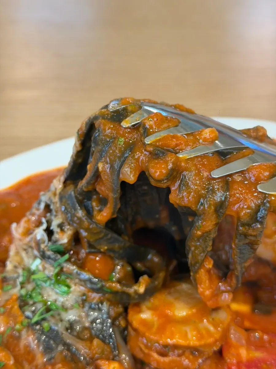 Seafood tomato fettuccine made with squid-ink fresh noodles