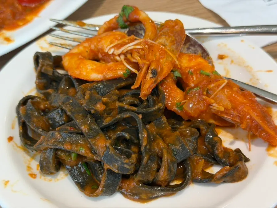Close-up of tomato fettuccine topped with scallops and mussels