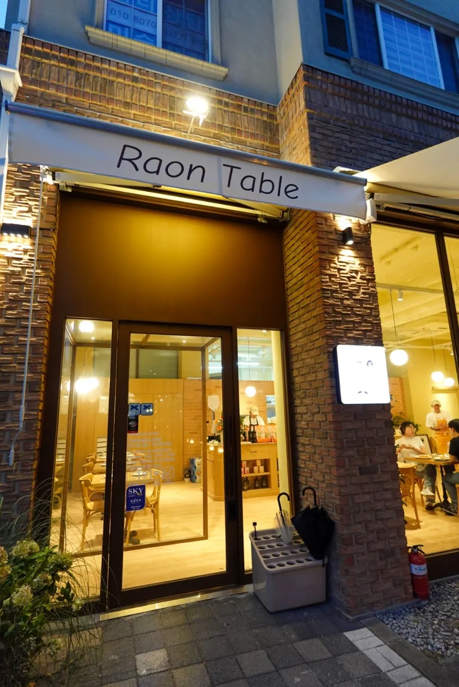 Evening street view of Baekhyeon-dong café street and the entrance to Raon Sik Tak