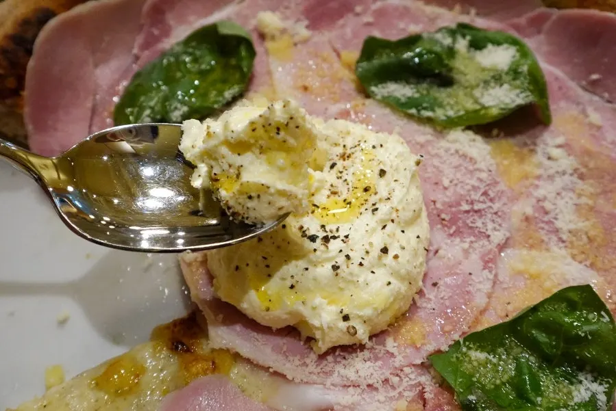 Ricotta cheese piled generously in the center of the pizza
