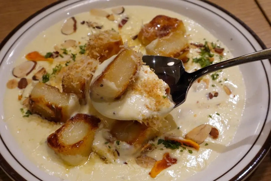 Plate of cream sauce with 8 pieces of gnocchi