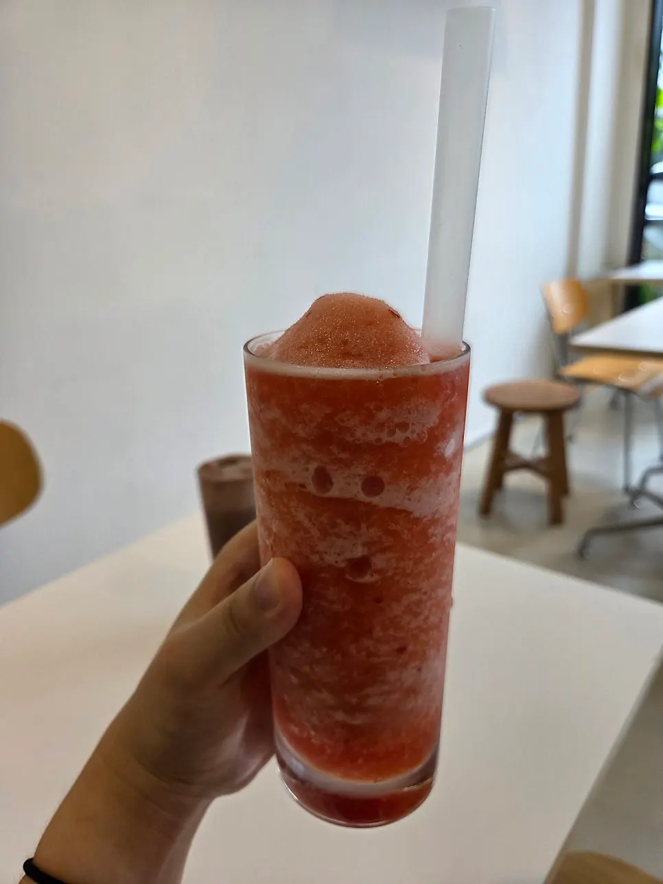 A glass of 100% plum red smoothie