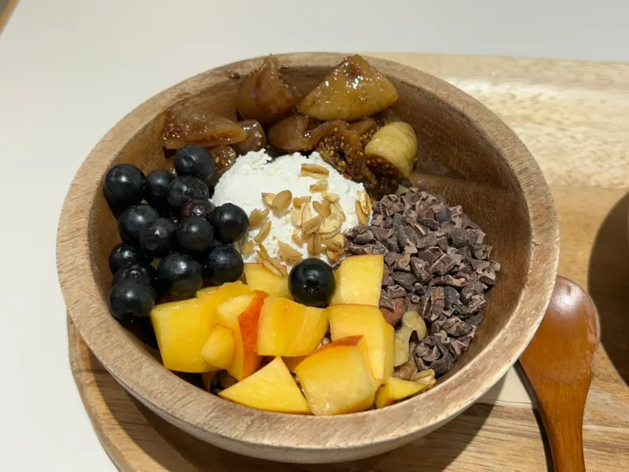Greek yogurt bowl in a wood bowl topped with fruit