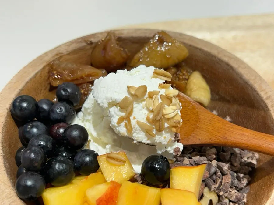 Plain Greek yogurt topped with peach and blueberries