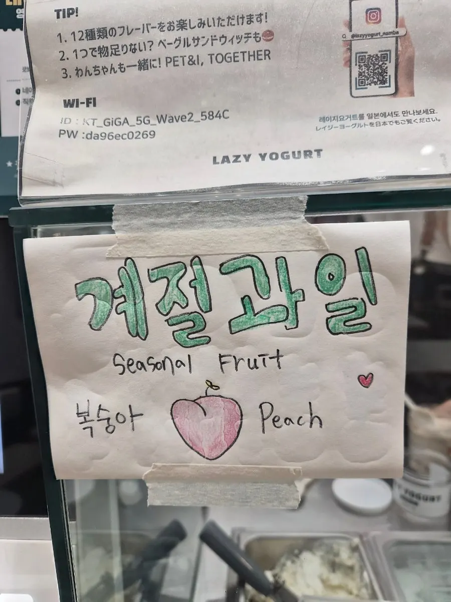 Sign listing Greek yogurt flavors and the seasonal fruit