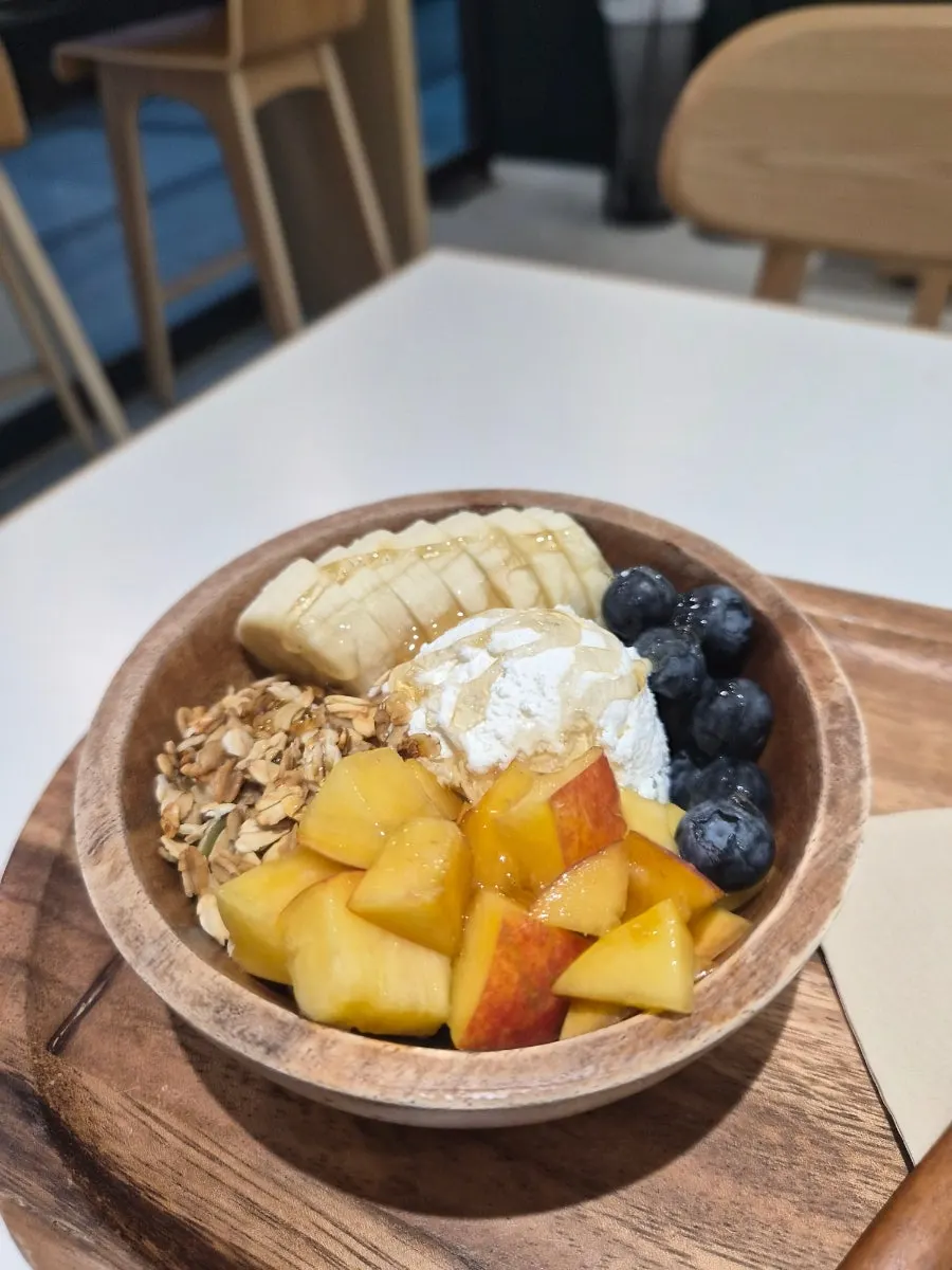 Yogurt bowl topped with banana and seasonal peach