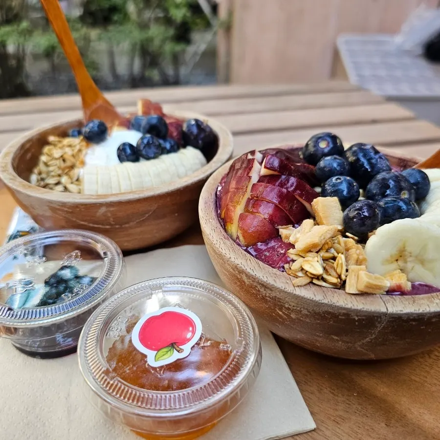 Greek yogurt and acai bowl placed together on the table