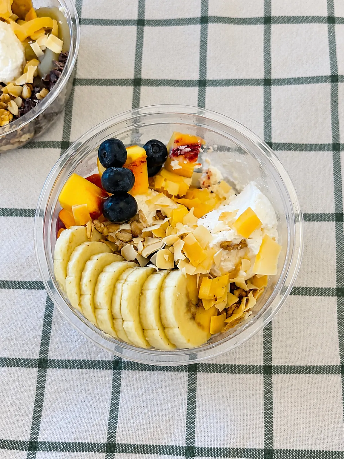 Beh double Greek yogurt topped with banana, blueberry, and plum