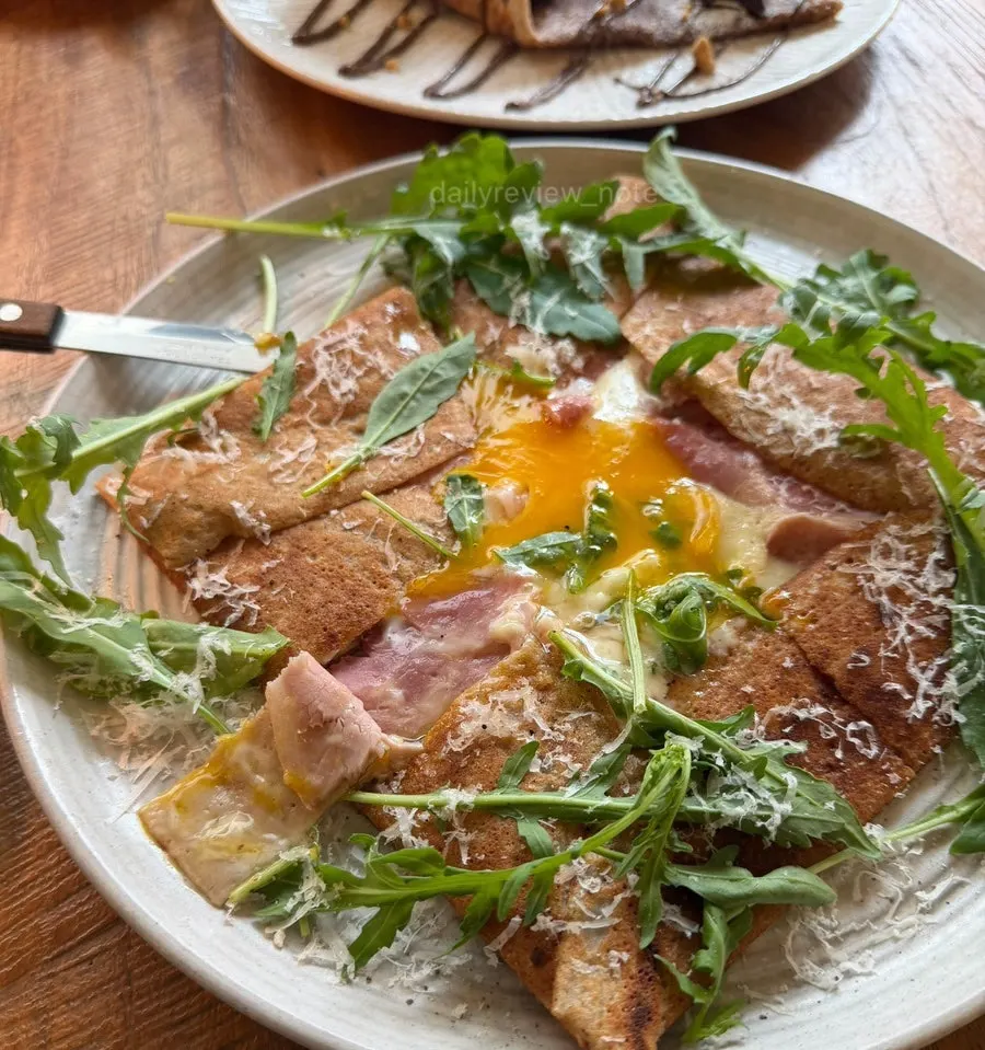 Egg yolk sitting in the center of the jambon cheese galette