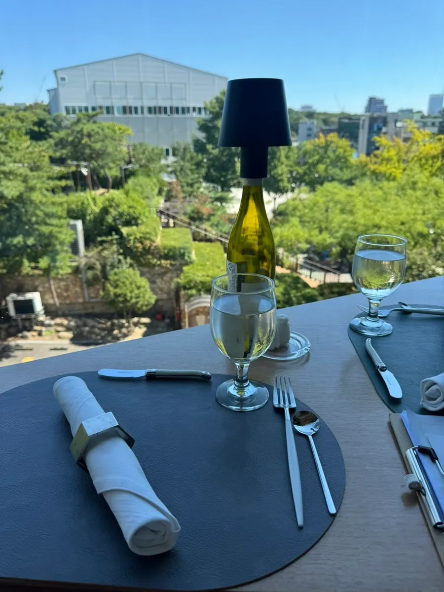 Le Cochon window seat with a green view through the floor-to-ceiling glass