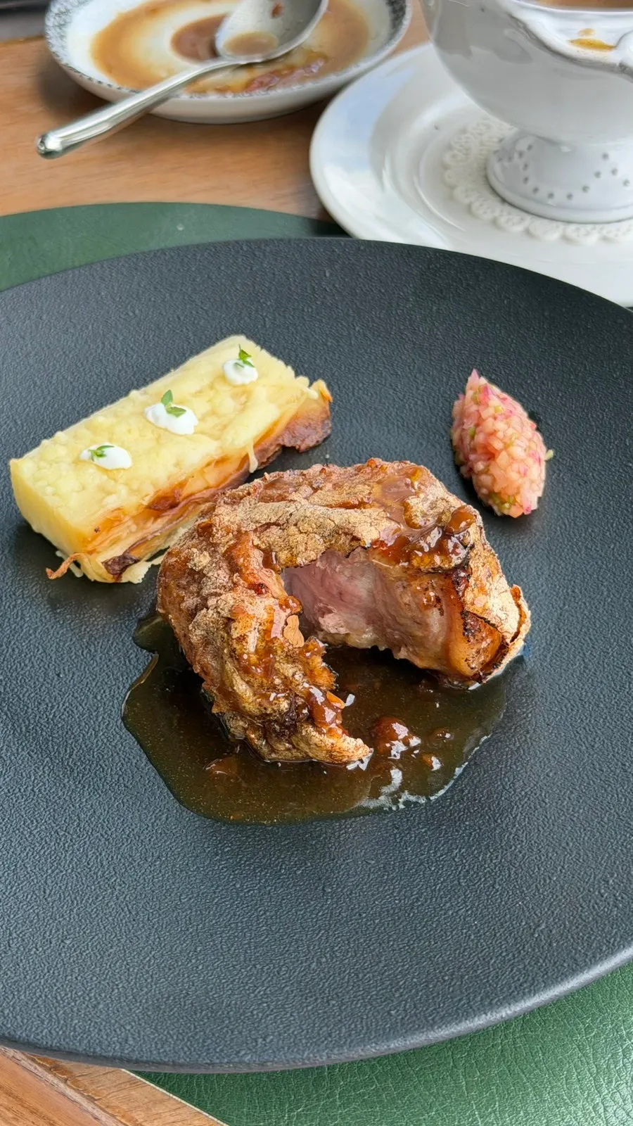Main dish plated with rich sauce and sides