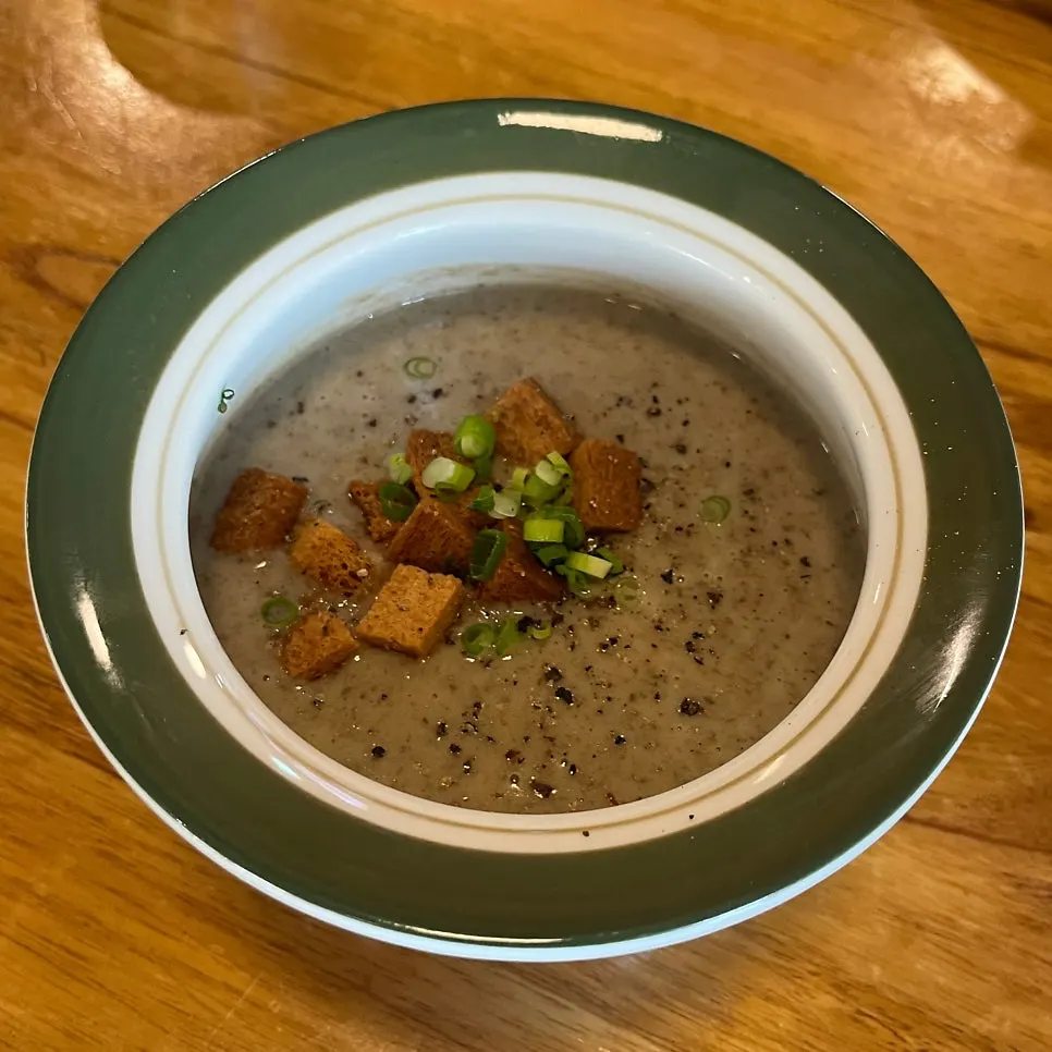 A bowl of mushroom soup packed with mushrooms