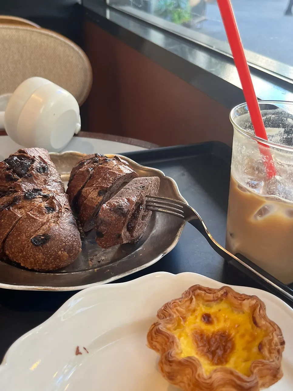 Bread and latte placed alongside a laptop