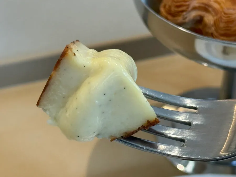 Creamy cheesecake interior lifted with a fork