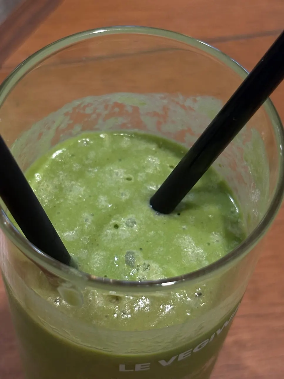 A glass of green smoothie made from avocado and kale