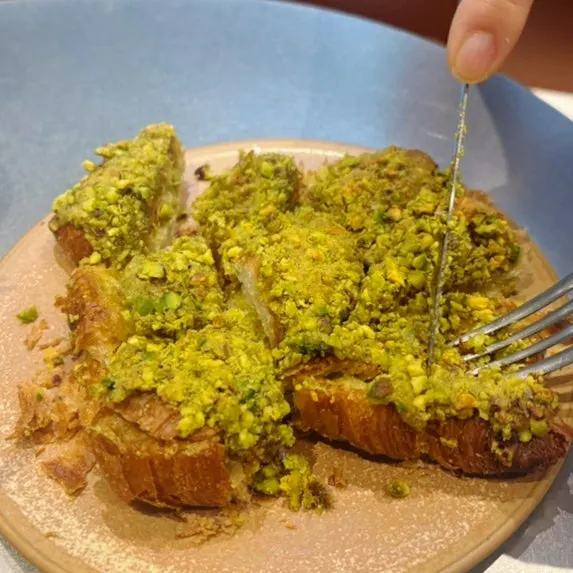 Close-up of the croissant topped with plenty of pistachio
