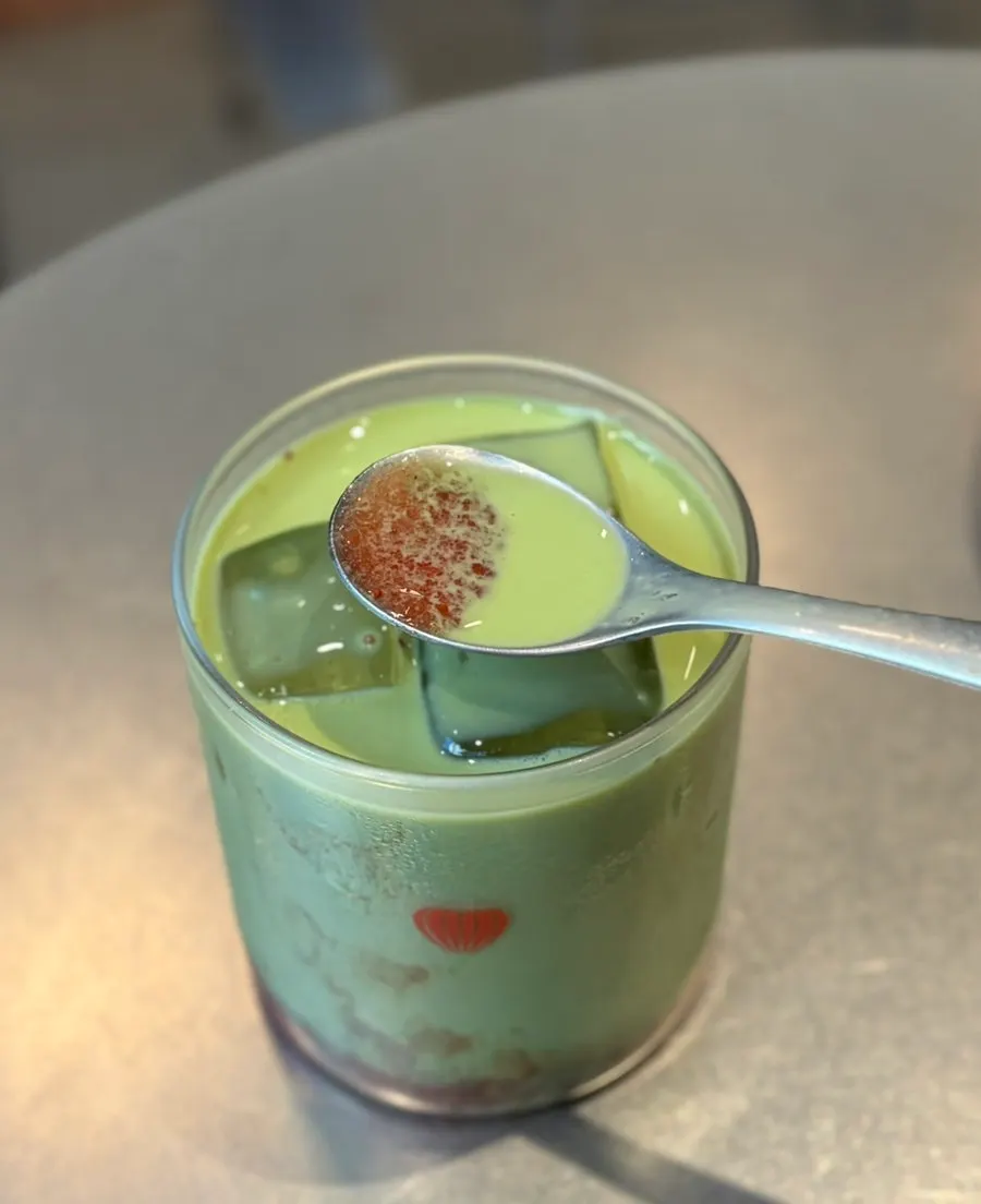 Cross-section of matcha latte with strawberry syrup layer