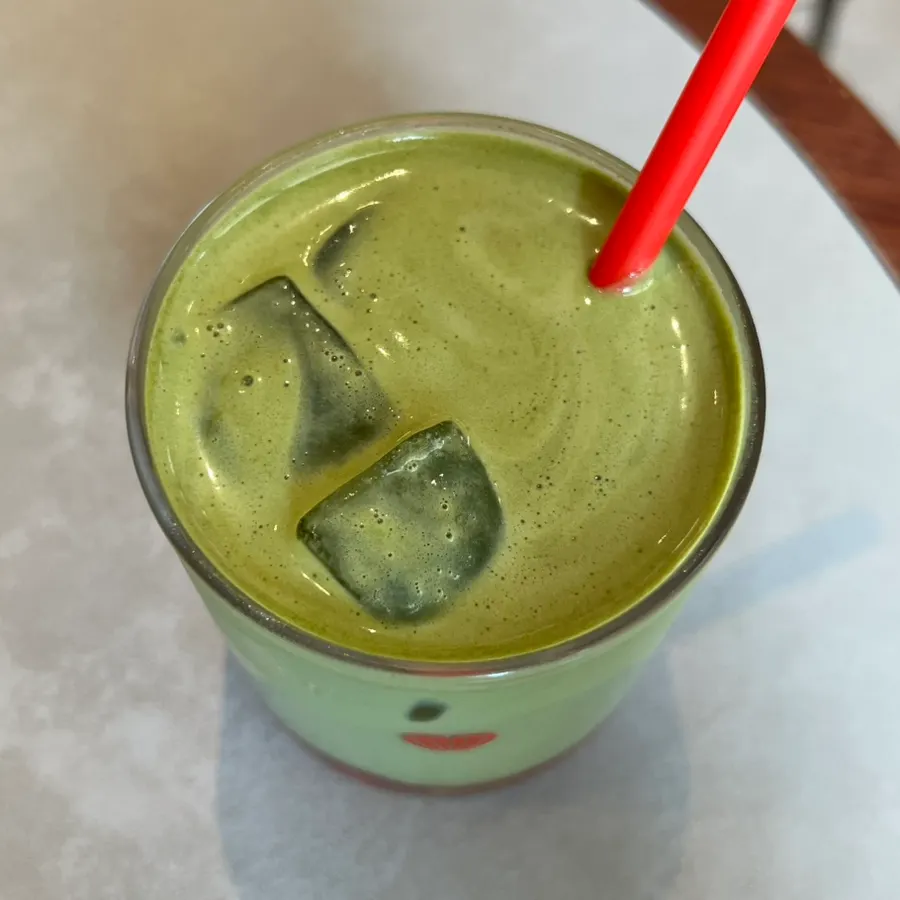 딸기청이 비치는 진한 말차 라테 잔