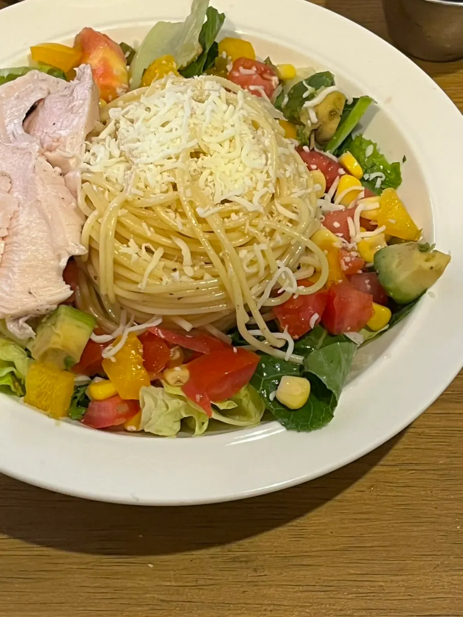 Nearly finished plates of poke bowl and salad pasta