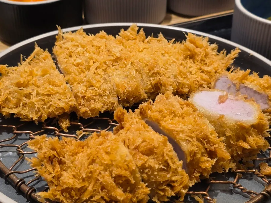 A piece of hire-katsu held with chopsticks