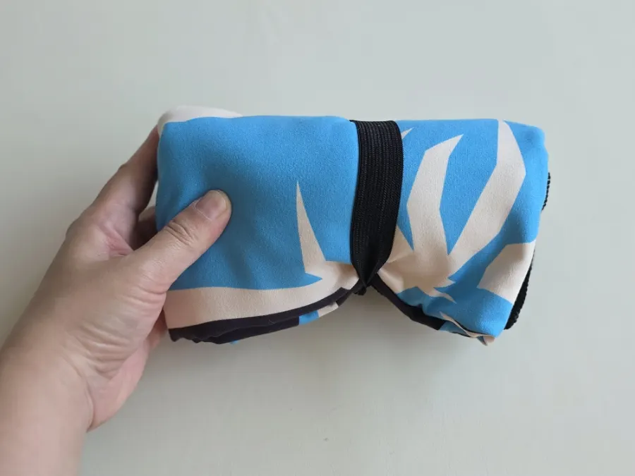 Attached elastic band securing the folded beach towel