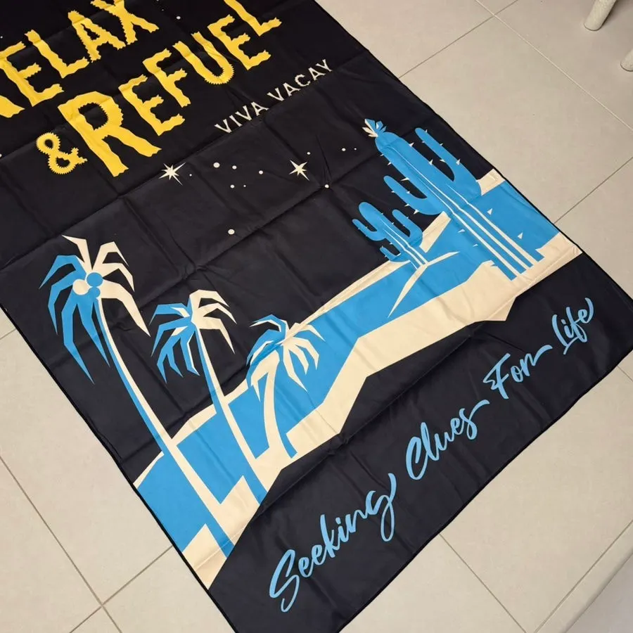 Black beach towel with a distinctive plant pattern