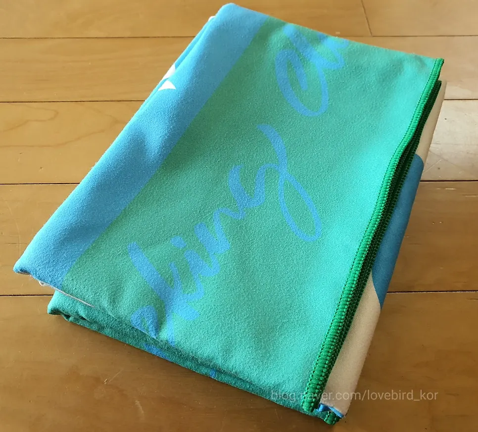 Beach towel with blue and white pattern on a green background