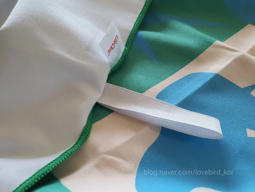 Beach towel rolled up and secured with an elastic band for storage
